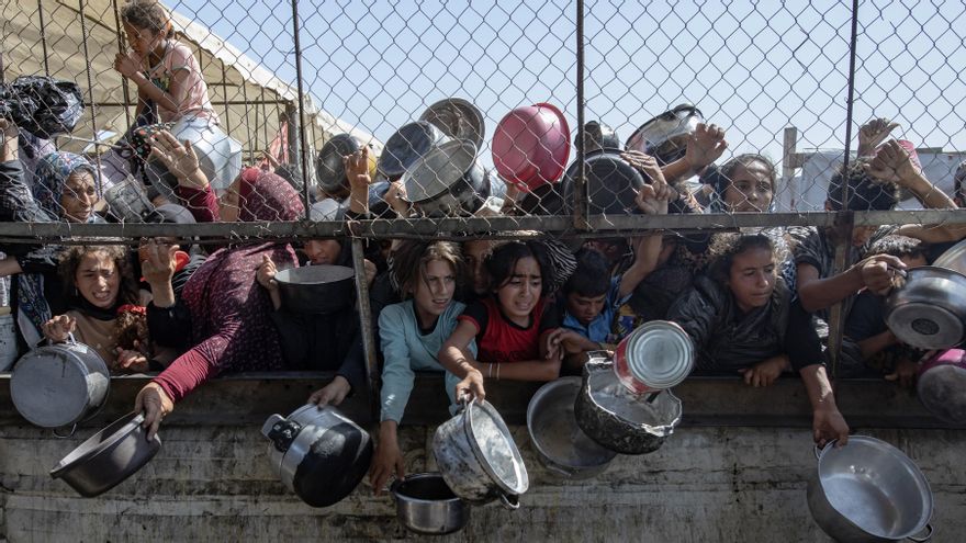 Palestinos desplazados frente a un comedor social para recibir raciones limitadas ante la escasez de alimentos, en Khan Younis, sur de la Franja de Gaza, en mayo de 2025.