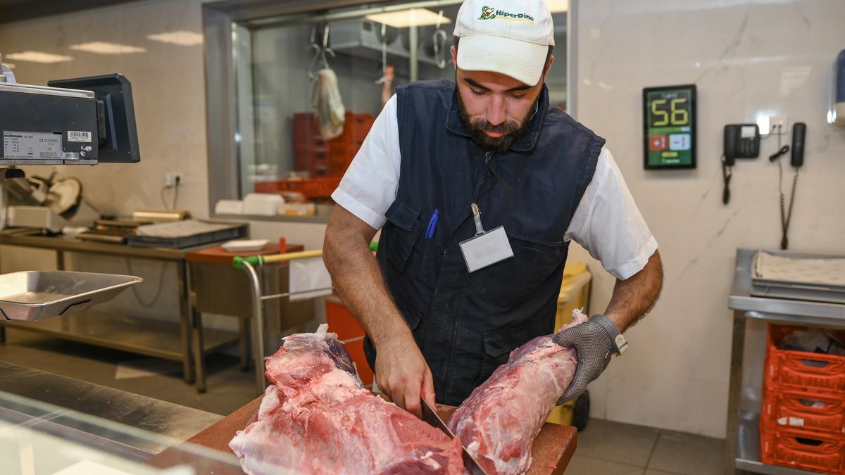 Un empleado de HiperDino, cortando carne.