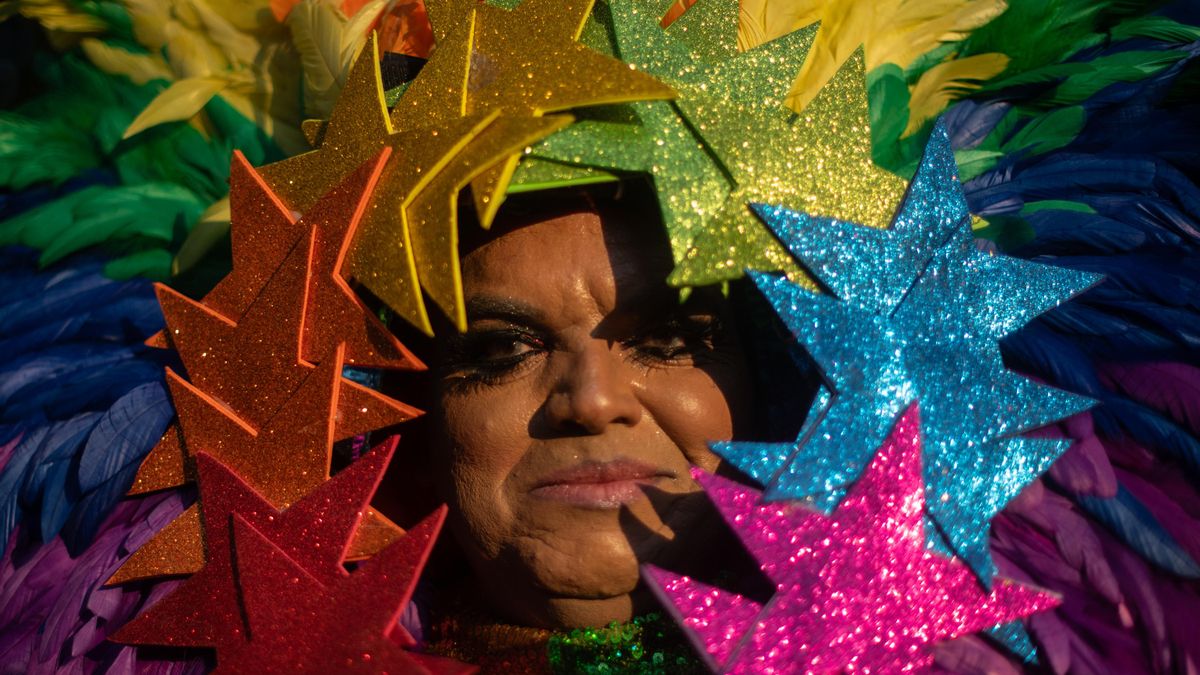 Una mujer disfrazada de fantasía con los colores de la bandera LGTBI.