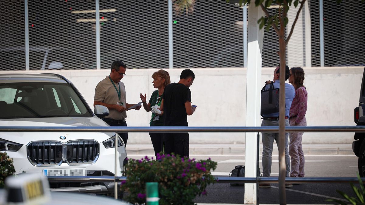 Dos treballadors d'una empresa de lloguer parlen entre ells a l'aparcament exprés de la terminal eivissenca