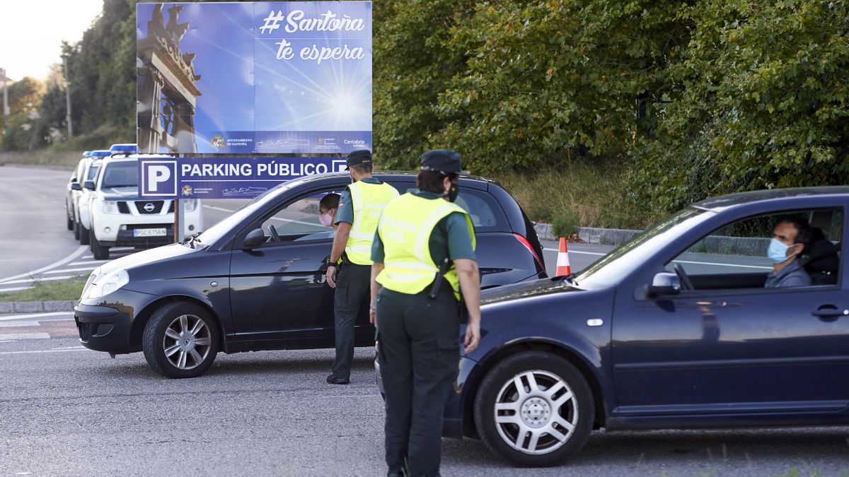 Agentes de la Guardia Civil controlan los permisos de entrada y salida durante el primer día de confinamiento relativo en el municipio de Santoña.