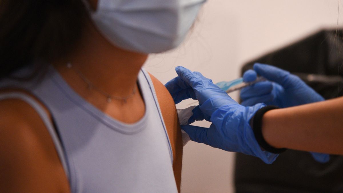 Una adolescente recibe la primera dosis de la vacuna Pfizer.