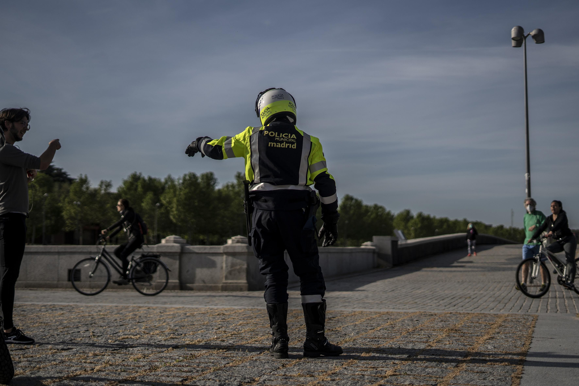 Un policía municipal ordenando salir a la gente que estaba practicando deporte en Madrid Río, cerrado por cintas policiales.