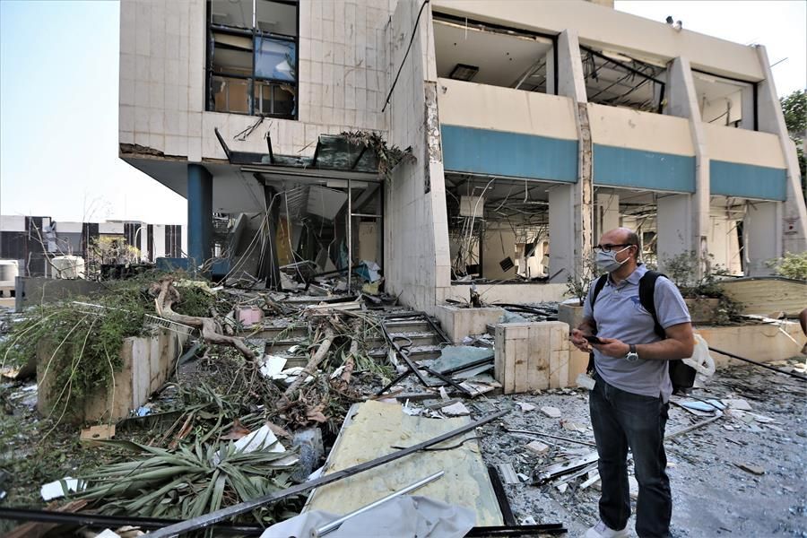 Un hombre al lado de su oficina un día después de la explosión en el puerto de Beirut.