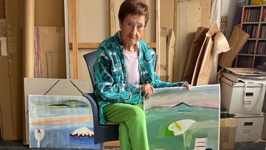 Gloria Torner, en el estudio junto a sus cuadros.