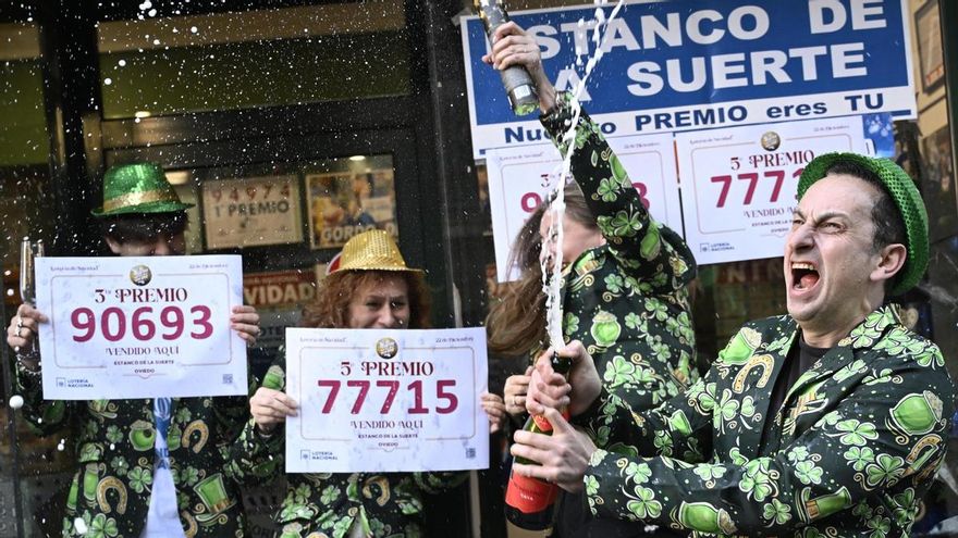 Empleados de la administración de lotería de Oviedo 'Estanco de la suerte' celebran tras haber vendido décimos del 90693, el tercer premio, y del 77715, uno de los quintos premios