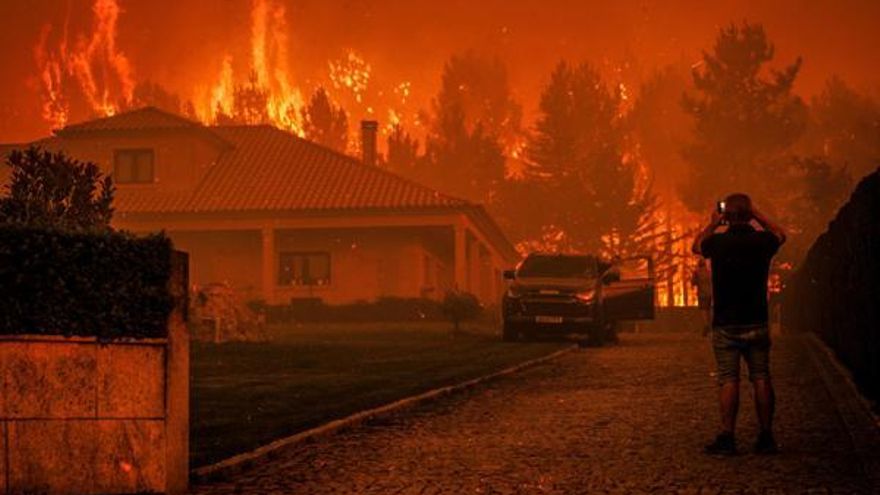 Un hombre observa cómo un incendio forestal se desata cerca de una casa en Granja do Paiva, municipio de Sernancelhe.