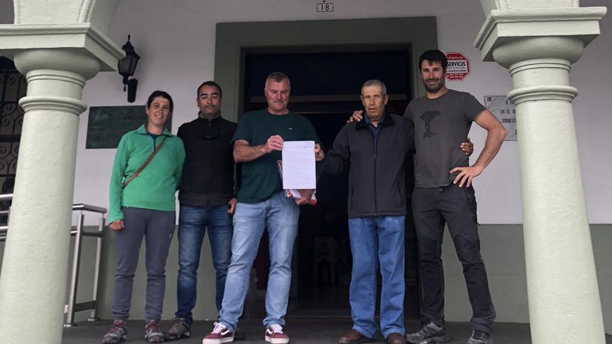 El  grupo de  vecinos  muestra el documento con las firmas recogida presentado ante el Ayuntamiento de El Paso.