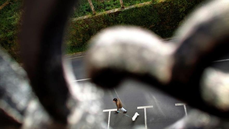 Un hombre y su perro pasean por las inmediaciones de su casa en el concello coruñés de Pontedeume este sábado.