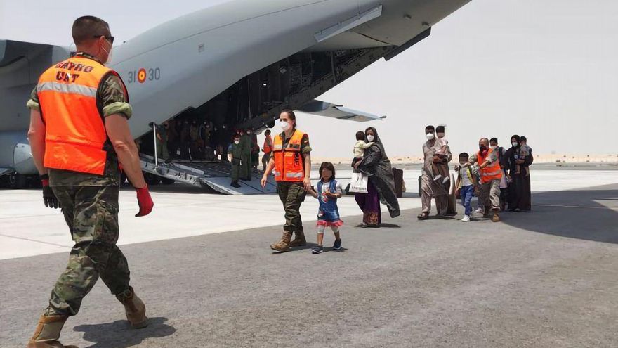 Afganos junto a un avión español de las fuerzas armadas en el aeropuerto de Dubái, Emiratos Árabes Unidos, tras despegar desde el aeropuerto de Kabul con un grupo de 110 personas evacuadas de Afganistán. EFE/Ministerio De Defensa