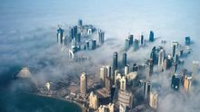Una vista aérea de los rascacielos que emergen a través de la niebla que cubre el horizonte de Doha, Qatar