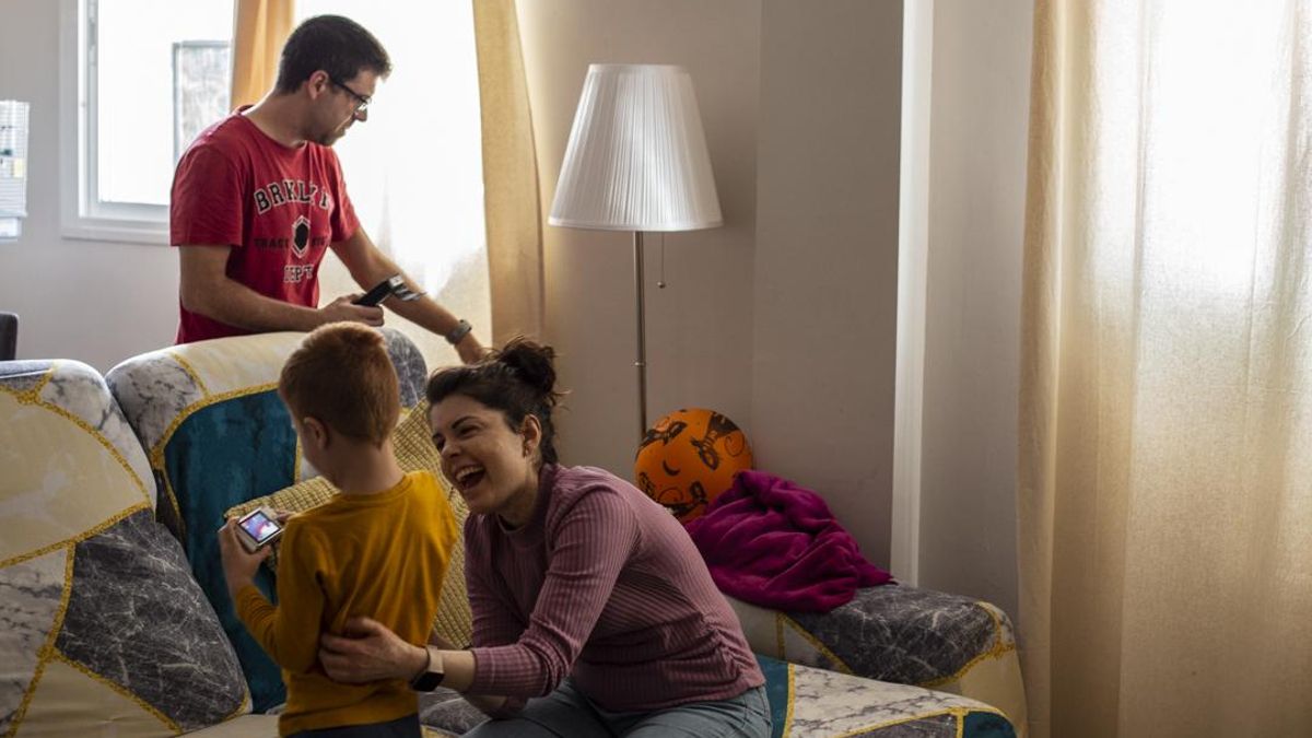 Susana en el salón de su casa mientras su marido comprueba que no haya rayos ultravioletas que traspasen las láminas de poliéster que protegen la radiación