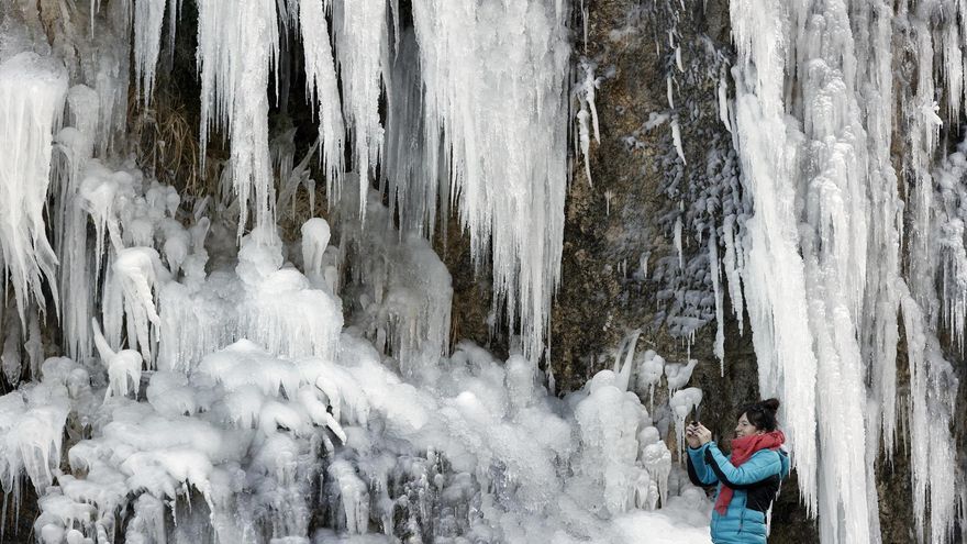 Una persona fotografía este martes los carámbanos de hielo que se han formado junto a la carretera NA-137 en el Valle del Roncal.
