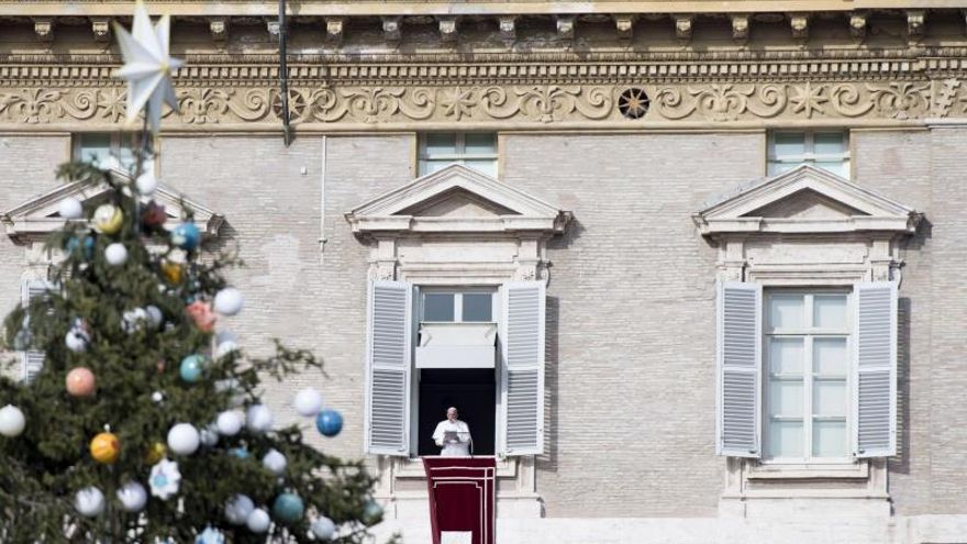 Vista de un árbol de Navidad frente al papa Francisco (i) durante el rezo del Ángelus en la Plaza de San Pedro, en Ciudad del Vaticano.