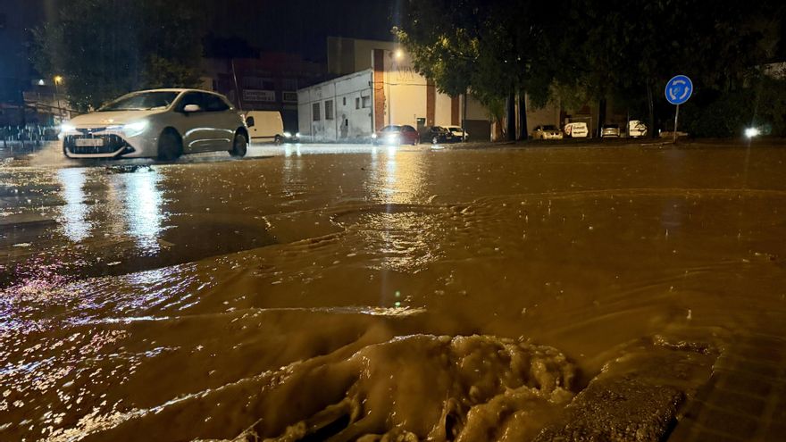 Un vehículo circula por una calle encharcada de la provincia de Barcelona este sábado.