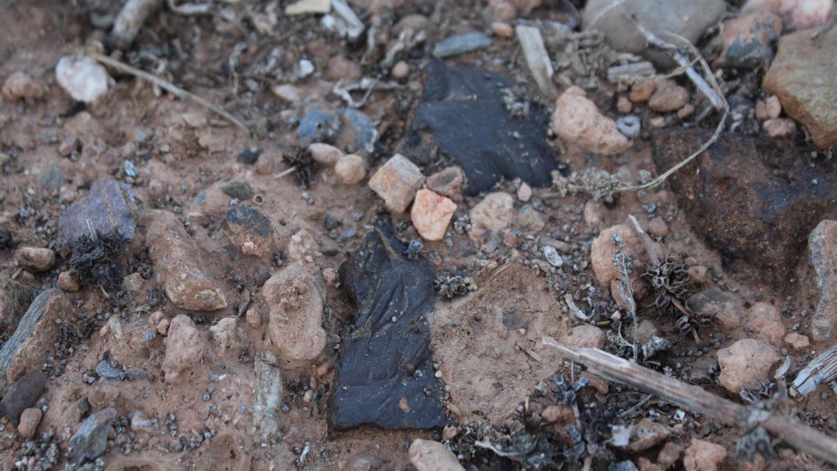 Black debris from lead smelting slag, which releases heavy metals over time, dominates El Lirio's sealed cover, exacerbating the process of contaminating the topsoil. Photographed in October 2025.