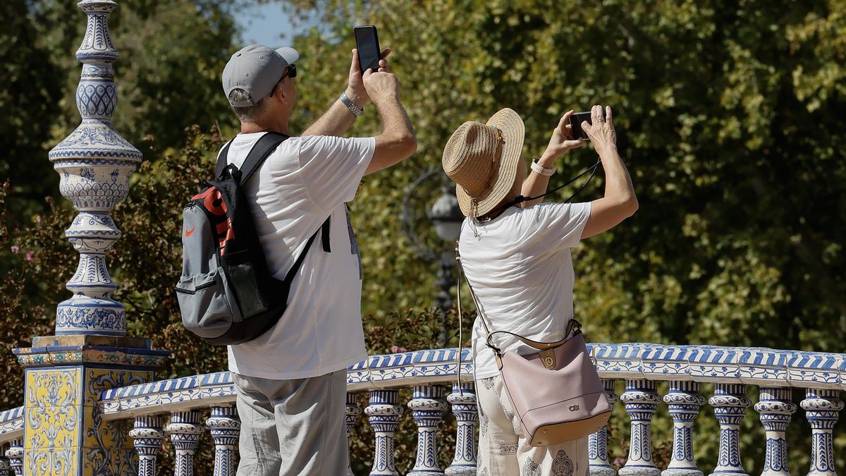 Unos turistas toman fotos en la plaza de España de Sevilla