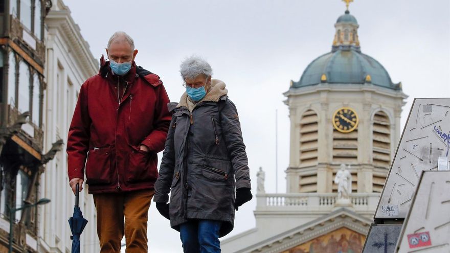 Una pareja pasea con mascarilla por el centro de Bruselas.