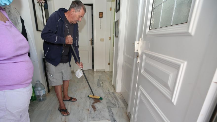 Joseph Huttley, vecino de Castillo del Romeral, barre polvo de las machacadoras en el interior de su casa, detrás de una puerta doble, solo horas después de haber barrido por última vez.