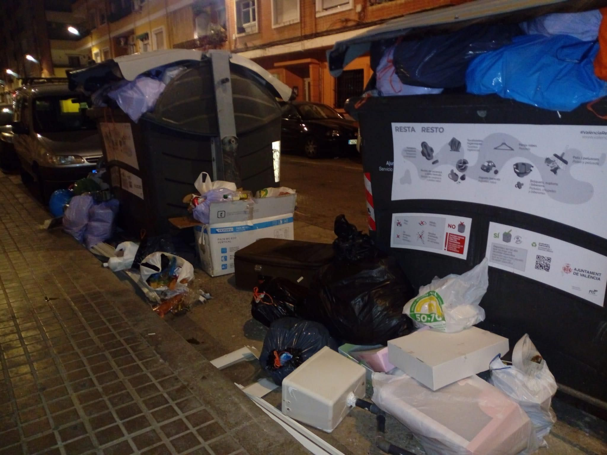 Contenedores con la basura desbordada en una calle de Orriols.