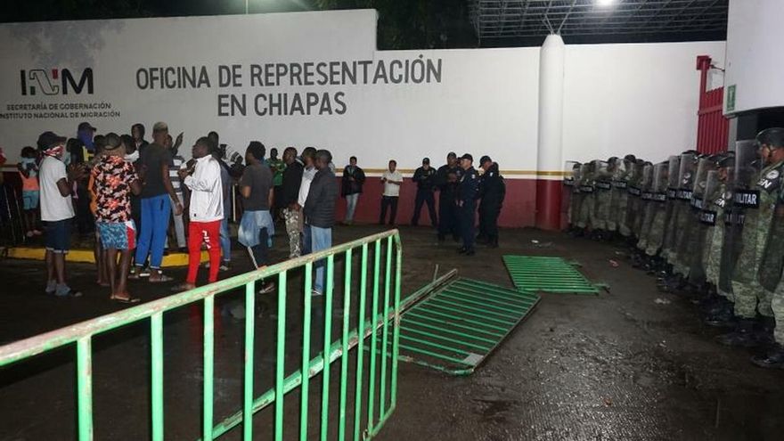 Migrantes de origen africano protestan ante la vigilancia de policías militares en la madrugada de este jueves, en la garita Siglo XXI de la ciudad de Tapachula, estado de Chiapas (México).
