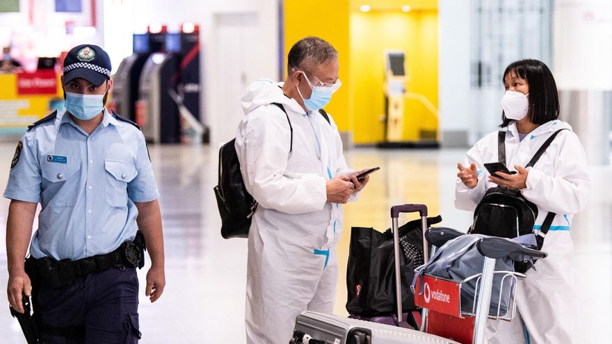 Viajeros con trajes de protección llegan al aeropuerto Internacional de Sídney (Australia). EFE/EPA/JAMES GOURLEY