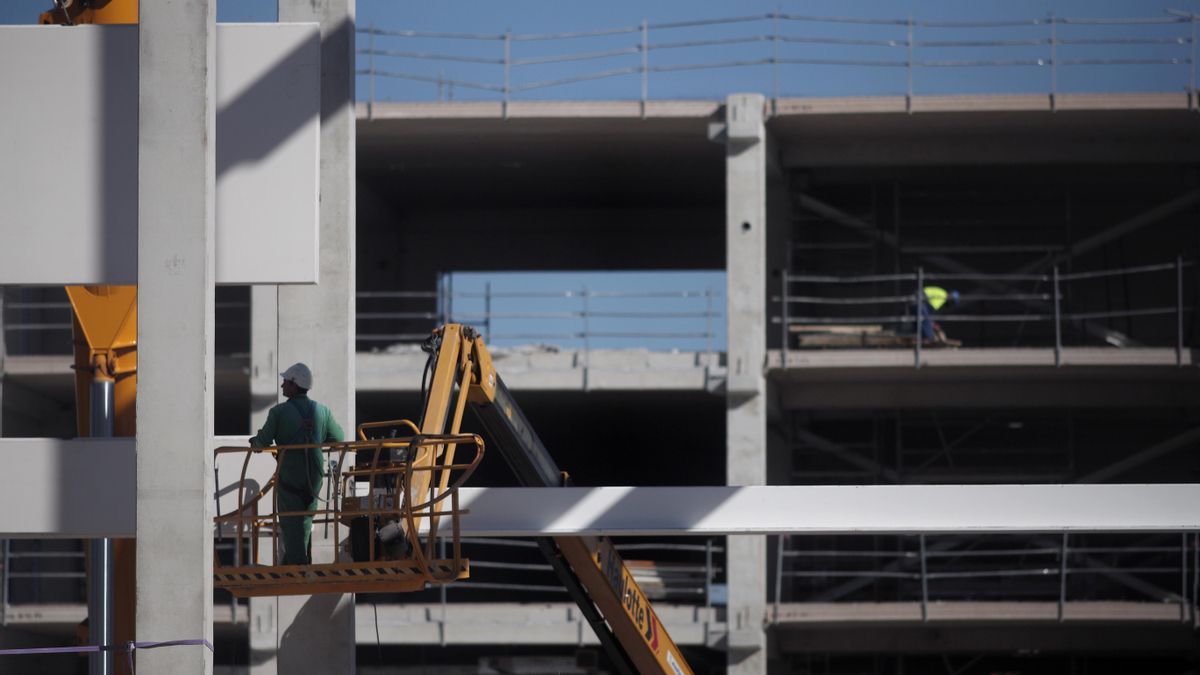 Varios obreros trabajan con maquinaria de construcción
