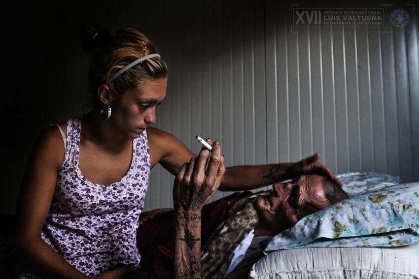 Ana, una de los residentes más jóvenes de La Casa de la Buena Vida , cuida de Juan. Juan, de 49 años, tiene SIDA y fue dado de alta recientemente cuando los médicos no pudieron hacer nada más por él. No tiene familia, su única "familia " es la de La Casa. La Casa es un refugio poco común, así como el centro de rehabilitación ubicado en una casa de campo en las colinas de Palma Palmilla, Málaga. Fue creada en 2006 por Jesús " Chule " Rodrigues, quien después de haber luchado contra la adicción a las drogas y el tiempo en la cárcel, decidió ayudar a los que están en la misma situación que él. La Casa cuenta con una política de puertas abiertas para cualquier persona que viene en busca de ayuda y refugio, así como apoyo para salir de las garras de las drogas y el crimen. El número de personas que viven allí fluctúa entre 30 y 80 personas. Aunque originariamente La Casa fue un lugar para la rehabilitación, también ha acogido con satisfacción a familias de inmigrantes sin recursos y sin lugar al que acudir, así como a los inmigrantes subsaharianos/ Wai Hnin Tun.