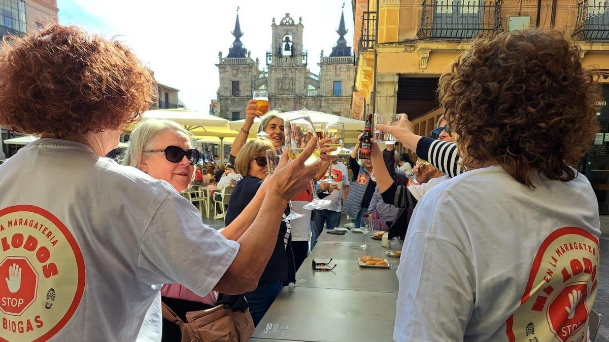 Miembros del frente de oposición vecinal a la planta de lodos de Piedralba, este sábado con camisetas y pegatinas por el centro de Astorga. 