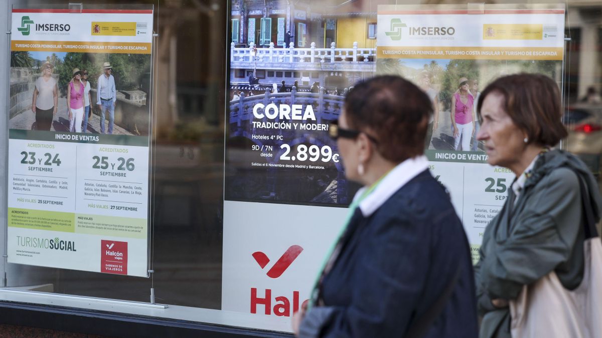 Dos jubiladas pasan en Bilbao por delante de una agencia de viajes donde anuncia viajes del Imserso en una imagen de archivo