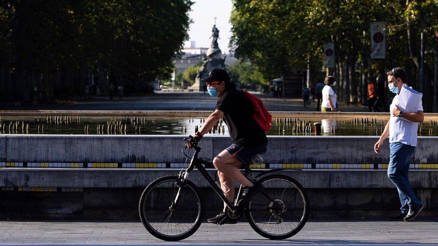 Un hombre circula en bicicleta y con mascarilla por el centro de la ciudad de Valladolid