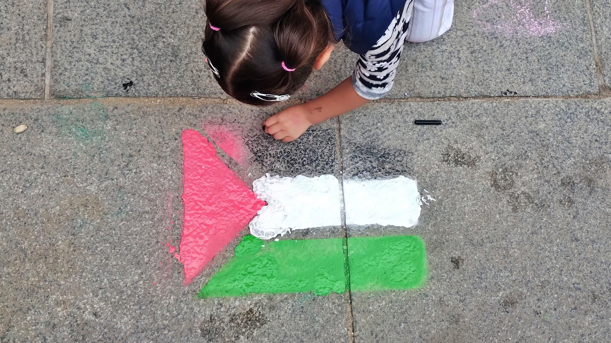 Una niña pinta una bandera palestina en la plaza del Dos de Mayo este martes