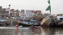 Niños juegan cerca de los cayucos amarrados a lo largo de la orilla del río Senegal, situada entre la Lengua de Barbarie -una estrecha península arenosa- y la Isla de Saint Louis, las dos áreas de la ciudad unidas con puentes a la otra parte, más extensa, que se sitúa en el continente africano