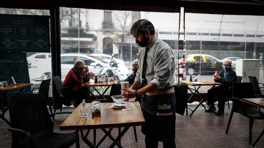 Un hombre atiende en un bar del centro porteño, uno de los sectores más afectados de la pandemia, en Buenos Aires
