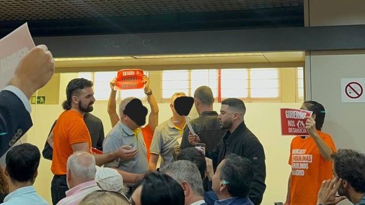 Los guardias de seguridad ordenan la salida de los manifestantes de la sala de subastas