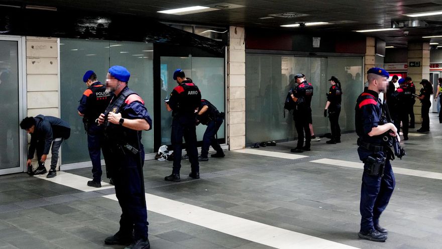 Agentes de los Mossos d'Esquadra identifican y cachean a personas este sábado, en el metro de Plaça Catalunya.