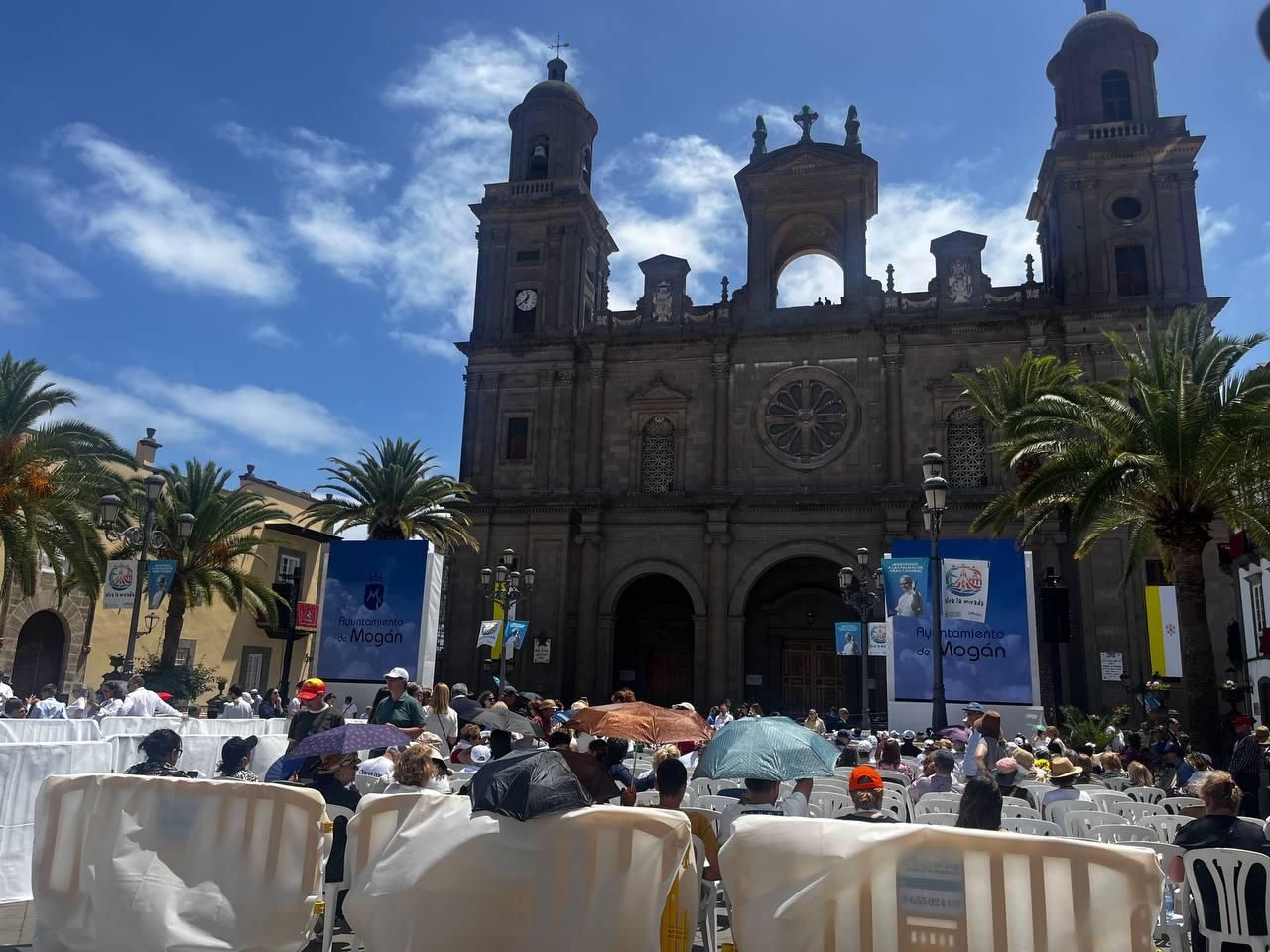 Asistentes a la Plaza de Santa Ana se protegenn del sol con paraguas.