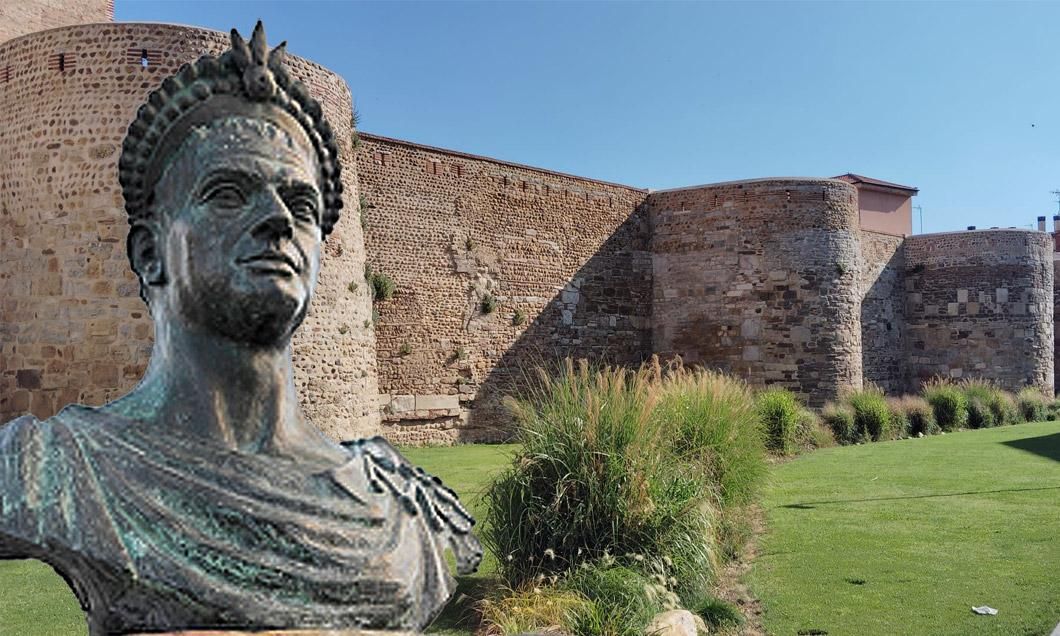 Busto de Teodosio en Segovia con las murallas romanas en la Era del Moro de León al fondo.