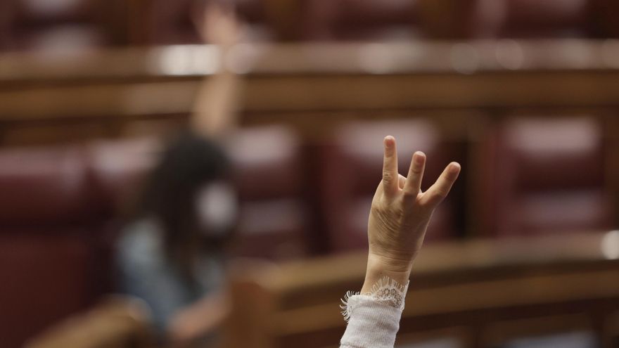 Archivo - Un miembro del hemiciclo vota durante una sesión plenaria en el Congreso de los Diputados