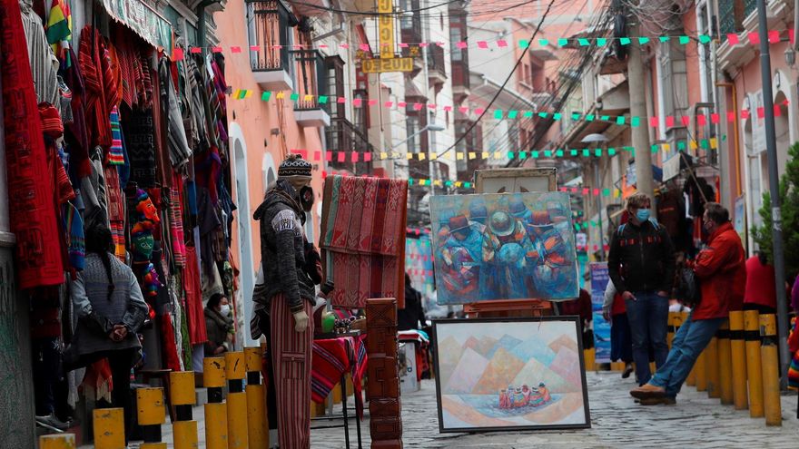 Grupo de turistas visitan las calles Linares y Melchor Jiménez, donde se encuentra el Mercado de las Brujas, que se cerraron hoy, al tráfico de vehículos para dar paso exclusivo a los peatones que quieran disfrutar del "Espacio en Movimiento" con la oferta de los artesanos y "chifleras", las vendedoras de plantas medicinales y elementos para rituales ancestrales, en La Paz (Bolivia).