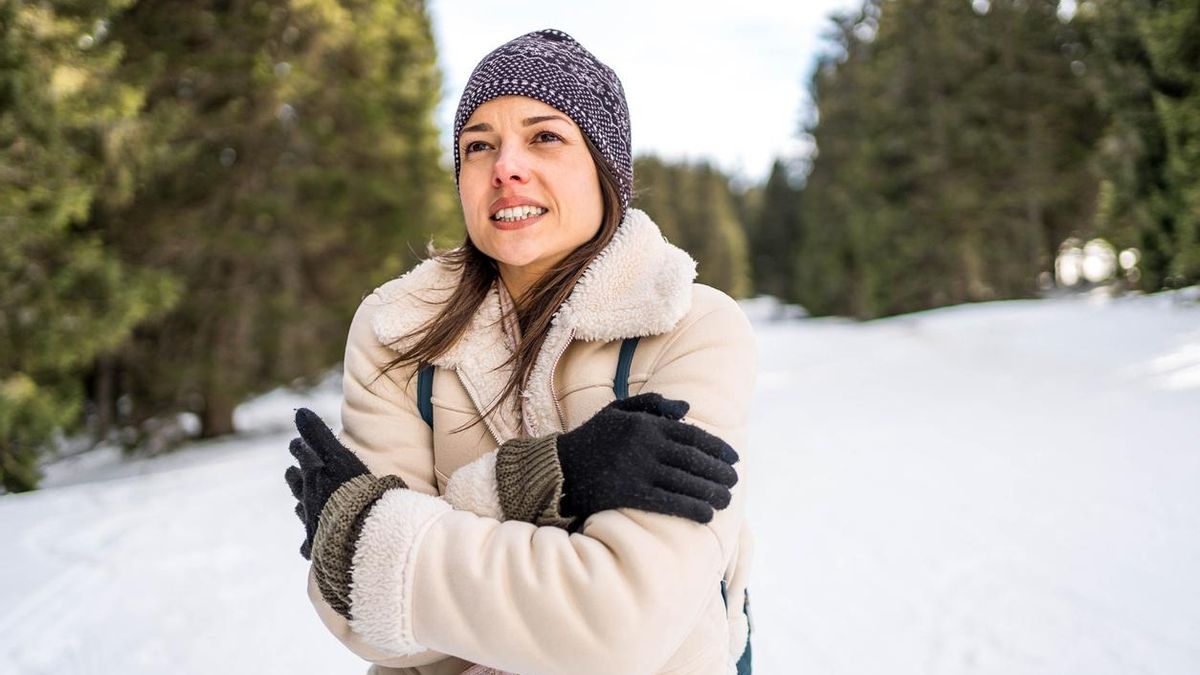 Una mujer tiene frío en la nieve