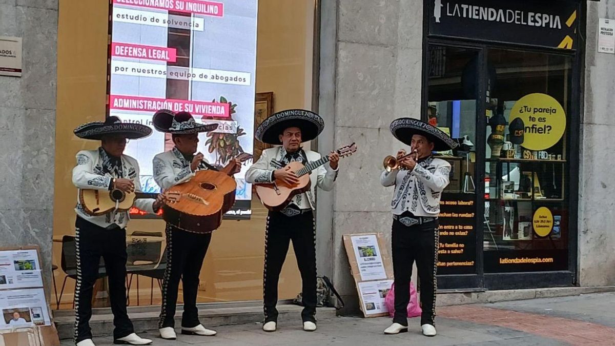 Mariachis tocando frente a los juzgados, junto a paneles con recortes de periódicos del 'casi DYA'.
