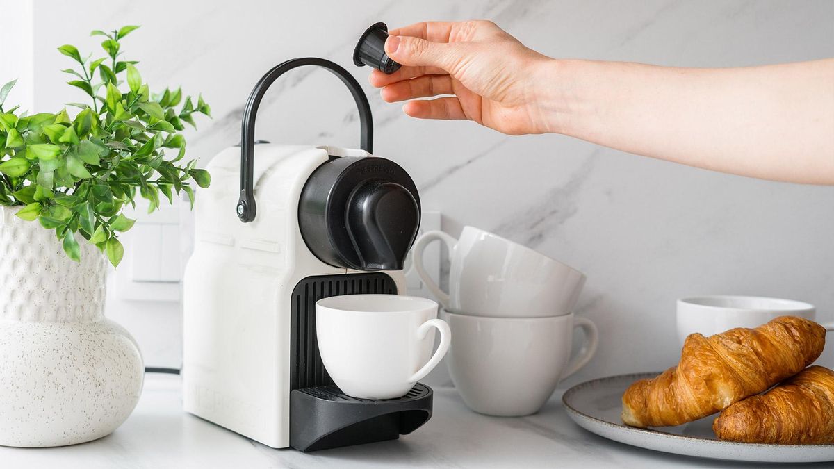 Una persona insertando una cápsula de café en una cafetera