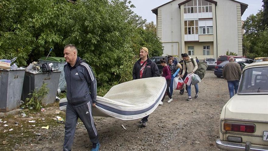 Personas trasladan sus pertenencias desde un edificio residencial dañado este lunes tras los bombardeos en Járkov, en el noreste de Ucrania.