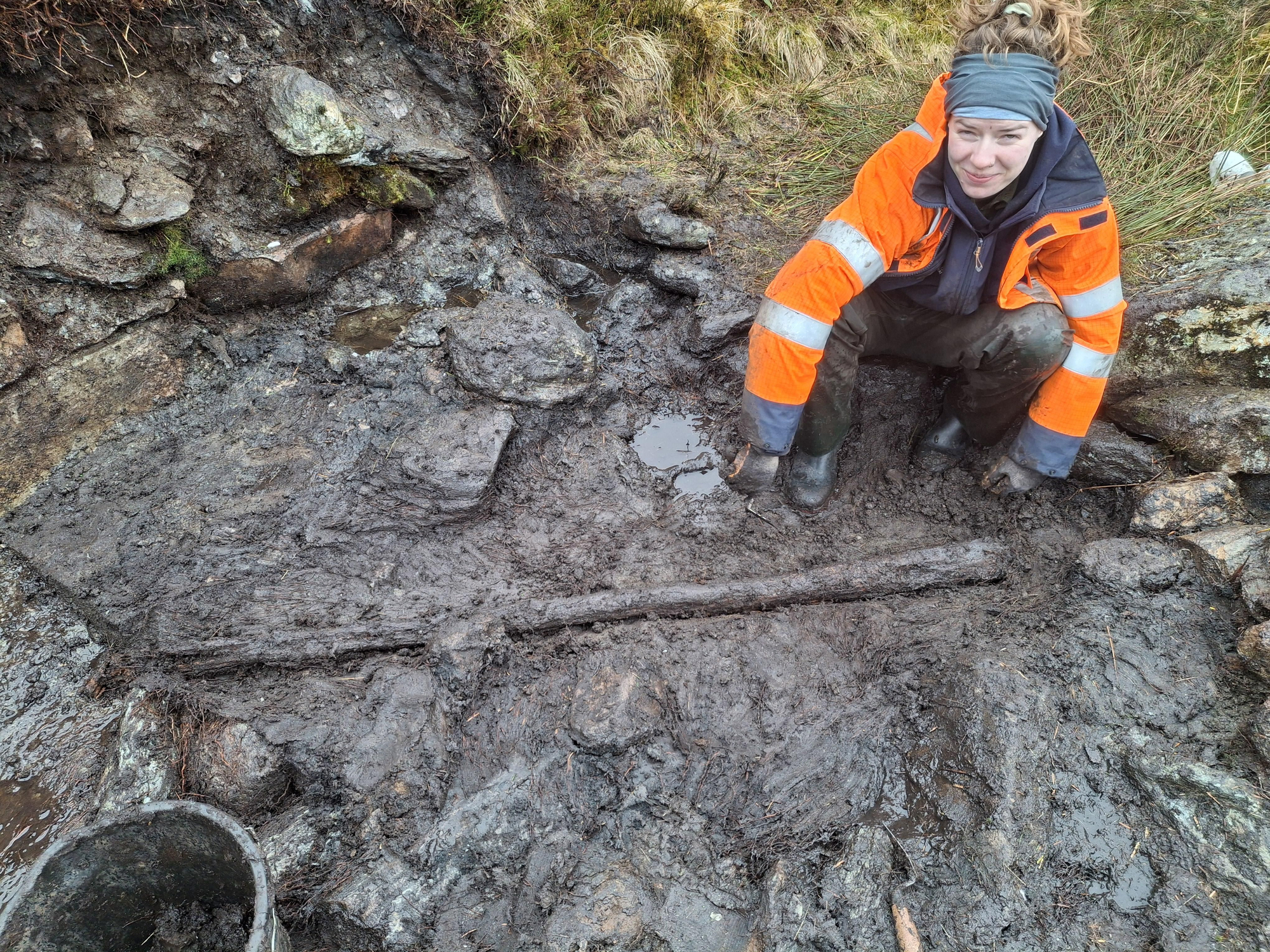 La estudiante de arqueología Alice Connelly junto al poste de madera en el lugar donde se destilaba whisky en la Reserva Natural Nacional de Ben Lawers.