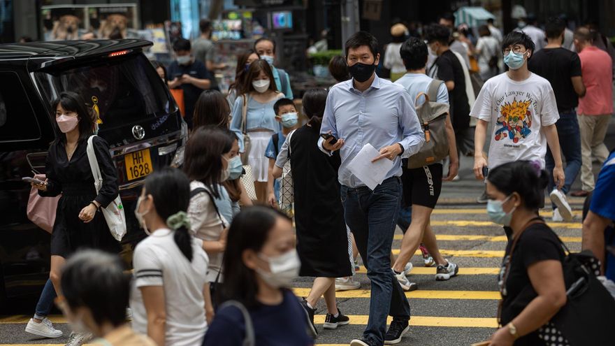 Numerosos peatones cruzan una intersección en Hong Kong, China