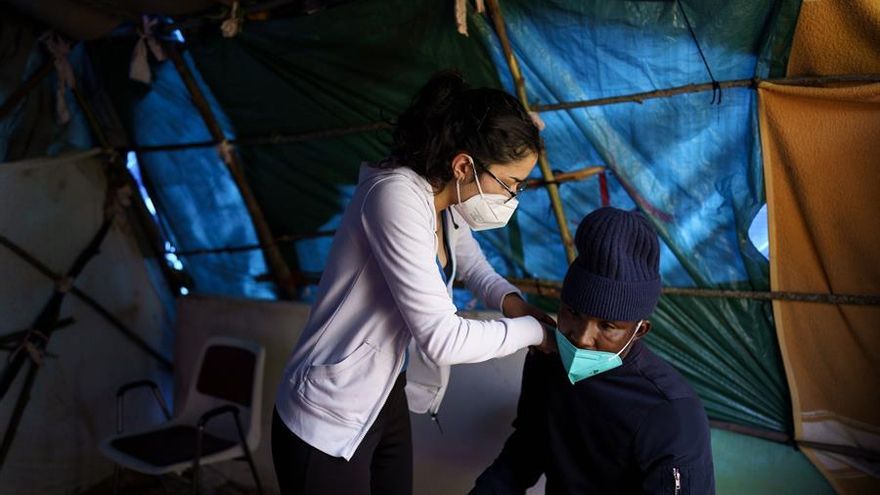 Rocío, una enfermera voluntaria, atiende a uno de los inmigrantes en el exterior del campamento