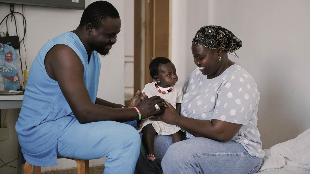 Gorgui, su mujer y su hija menor en el salón de su casa