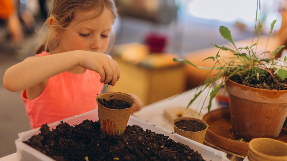 Niña cultivando plantas en clase
