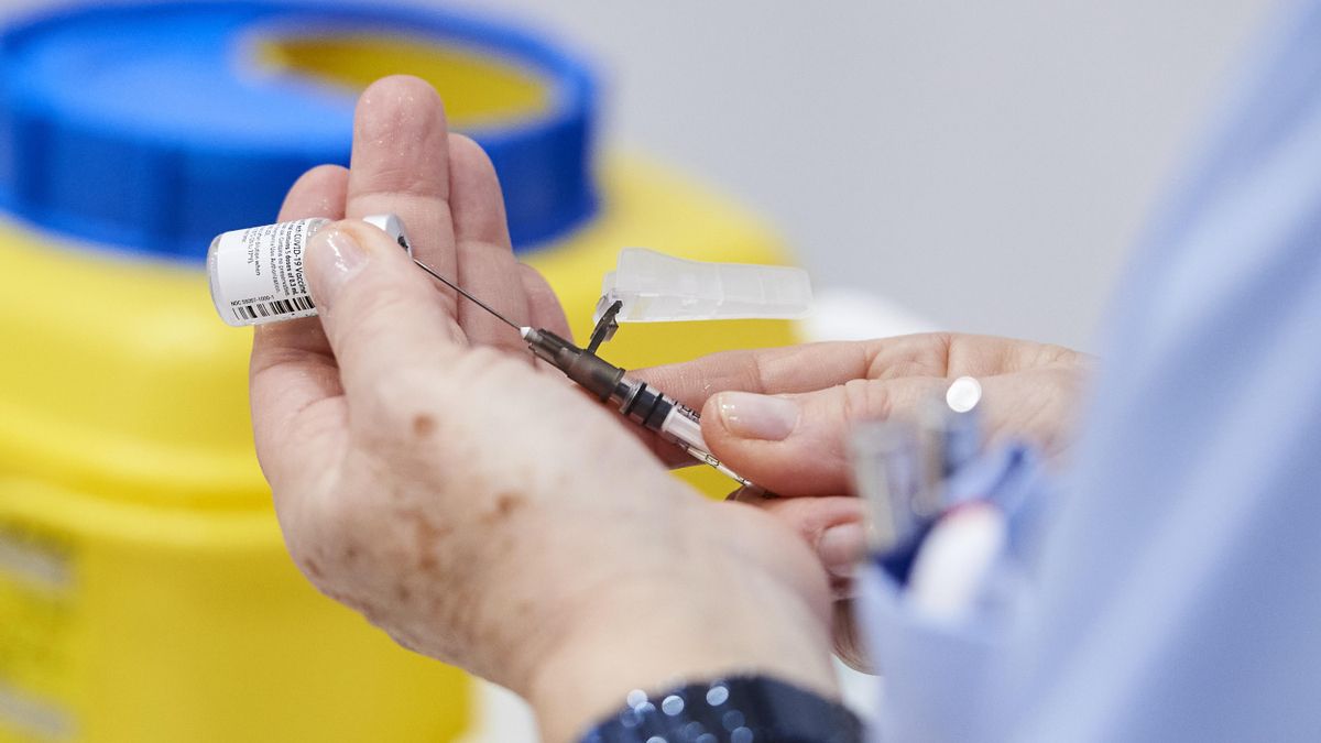 Una trabajadora sanitaria de Cantabria sostiene una vacuna contra la COVID. Archivo